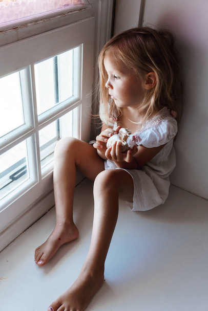 little girl sitting on the floor with a toy - Φωτογραφία, εικόνα