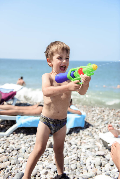 little boy with a toy on the beach - Fotoğraf, Görsel