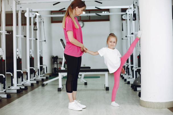 Мама с дочкой занимаются гимнастикой в спортзале
 - Фото, изображение