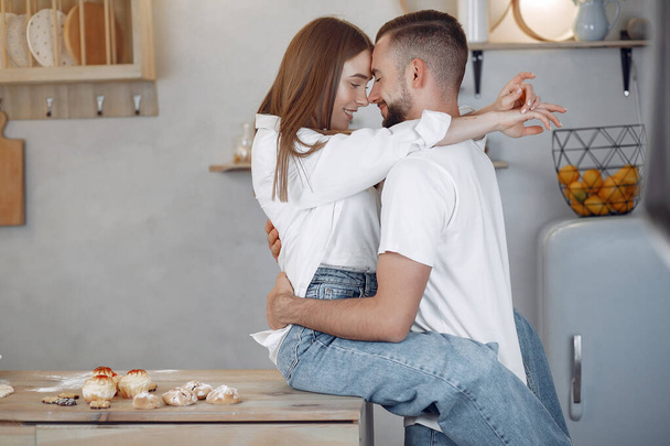 Beautiful couple spend time in a kitchen - Fotografie, Obrázek