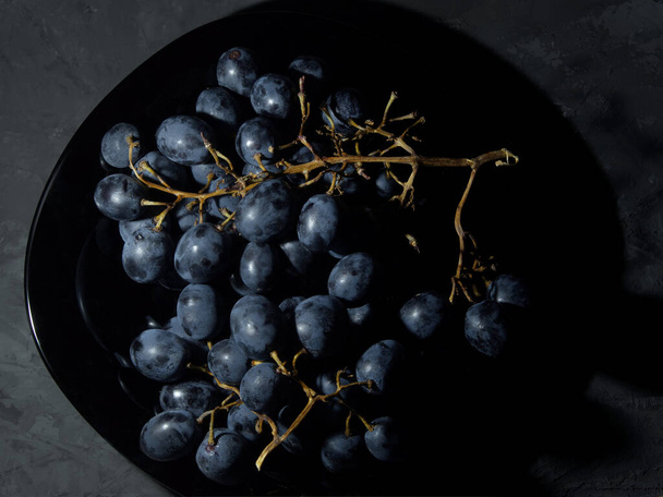 bunch of grapes on a plate black grapes - Zdjęcie, obraz