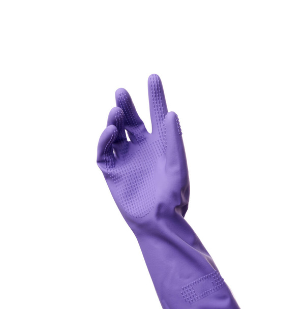 purple rubber glove for cleaning is dressed on his hand, his palm is open and conditionally holds an object - Photo, Image