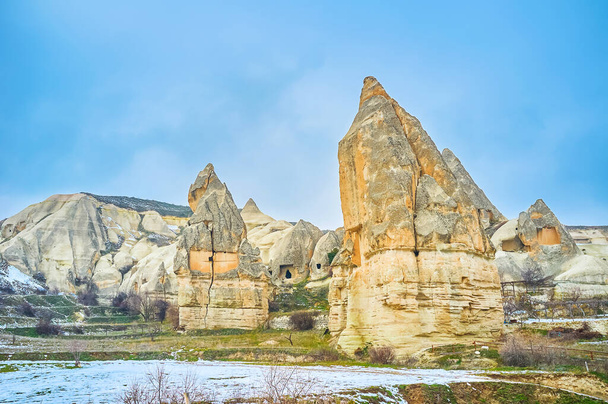 The fairy chimney rock formations of Cappadocia with ancient houses and homes, cut in soft tuff and preserved from olden times, Turkey - Фото, изображение