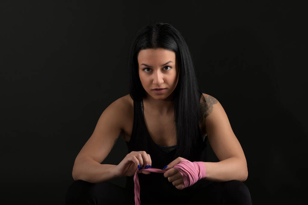 Boxe. Mulher boxer sentado no banco embrulhando bandagem em torno de mão close-up
  - Foto, Imagem