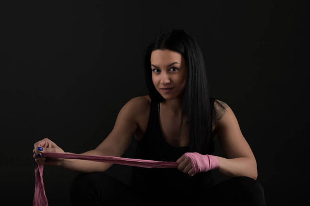 Boxe. Mulher boxer sentado no banco embrulhando bandagem em torno de mão close-up
  - Foto, Imagem