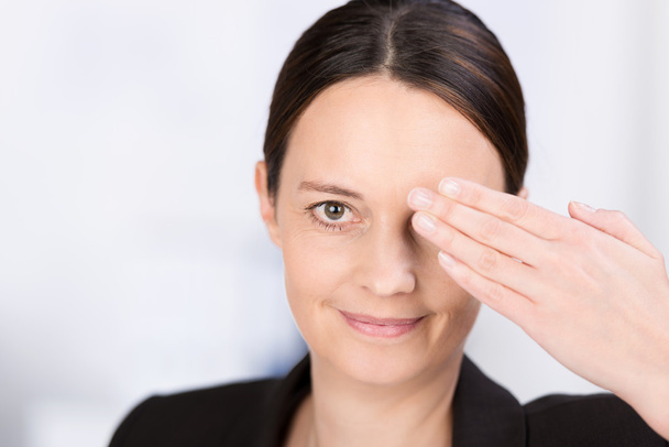 Woman covering one eye with her hand - Foto, immagini