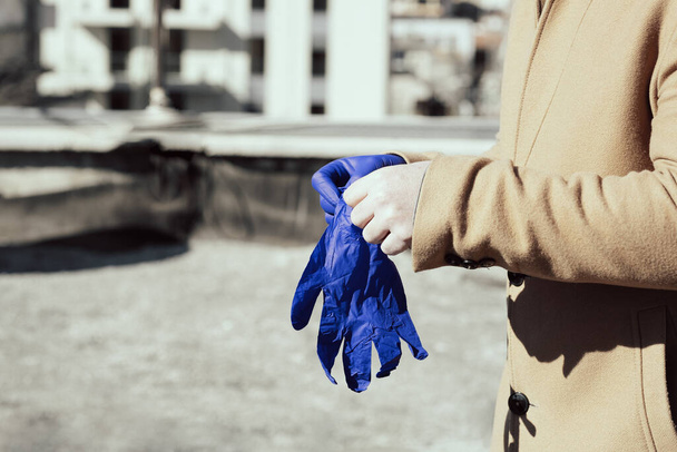 Man putting on medical gloves for protection from Coronavirus - Φωτογραφία, εικόνα