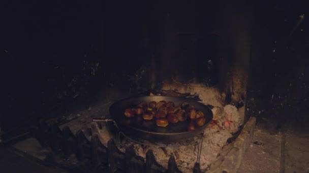 Geroosterde kastanjes bakken in de pan op de open haard in een herfstdag - Video