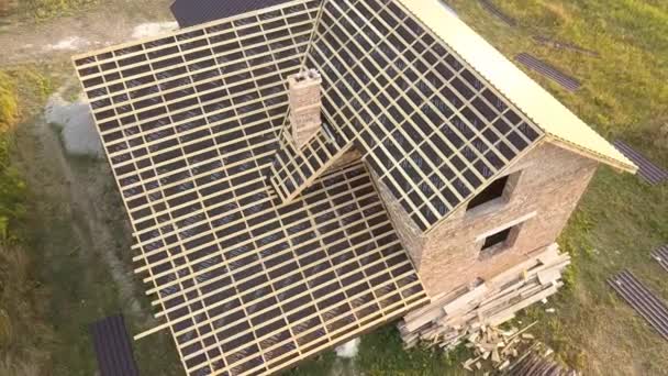 木造屋根構造の未完成の家の空中ビューは、建設中の金属タイルシートで覆われている. - 映像、動画