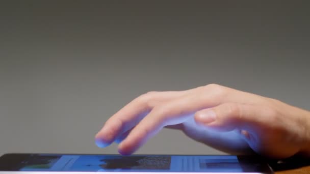 Крупный план мужской руки, переворачивающей ленту на мобильное приложение касаясь сенсорного экрана планшета
 - Кадры, видео