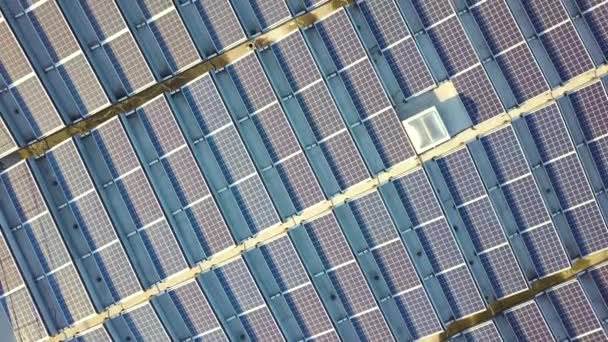 Vista aérea de muitos painéis solares fotovoltaicos montados no telhado do edifício industrial. - Filmagem, Vídeo