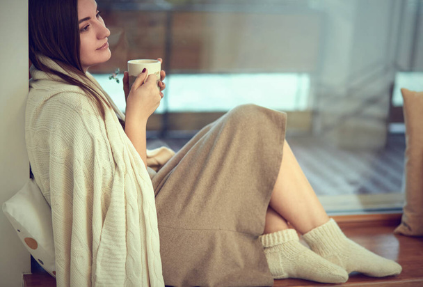 beautiful woman drinking coffee in the morning sitting by the window - Фото, изображение