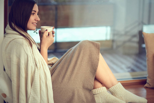 Hermosa mujer tomando café por la mañana sentada junto a la ventana
 - Foto, imagen