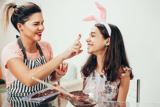 Mother and daughter making homemade chocolate easter eggs. Easter in Brazil. - Fotografie, Obrázek