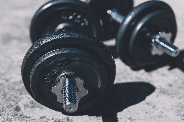 keeping fit and exercising outdoor or at home, set of heavy dumbbells on concrete path in a backyard - Фото, изображение
