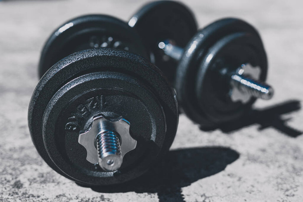 keeping fit and exercising outdoor or at home, set of heavy dumbbells on concrete path in a backyard - Photo, image