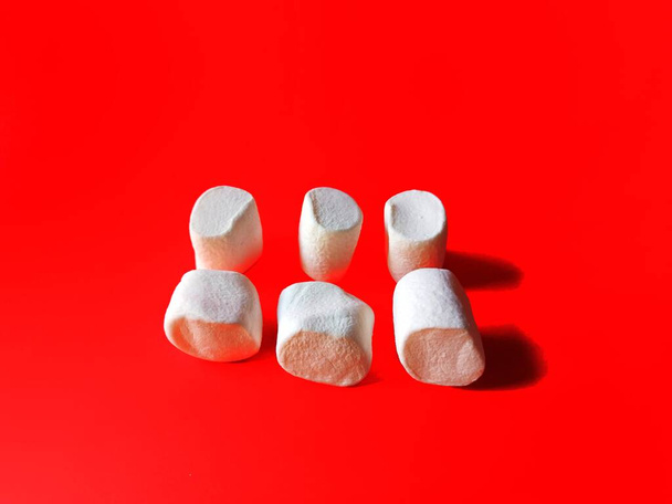 Marshmallows auf rotem Hintergrund. Urlaubskonzept - Foto, Bild