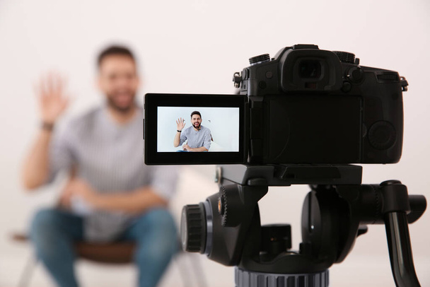 Young blogger recording video indoors, focus on camera screen - Foto, afbeelding