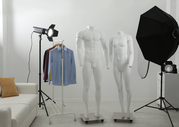 Ghost mannequins, clothes and professional lighting equipment in modern photo studio - Zdjęcie, obraz
