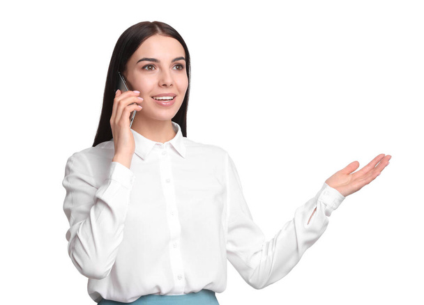 Young businesswoman talking on mobile phone against white background - Фото, зображення