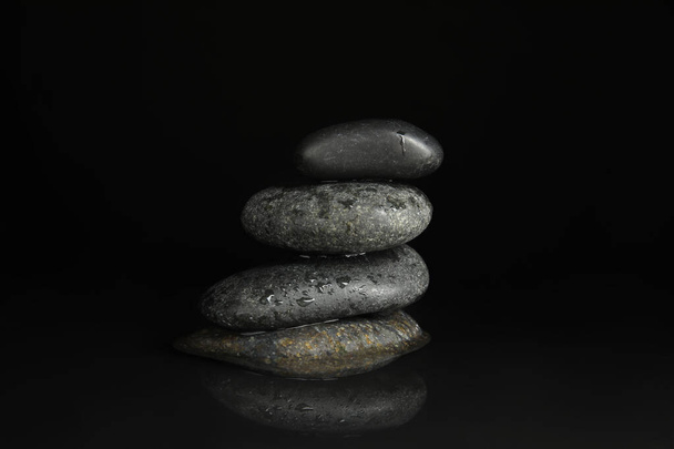 Stones in water on black background. Zen lifestyle - Photo, image