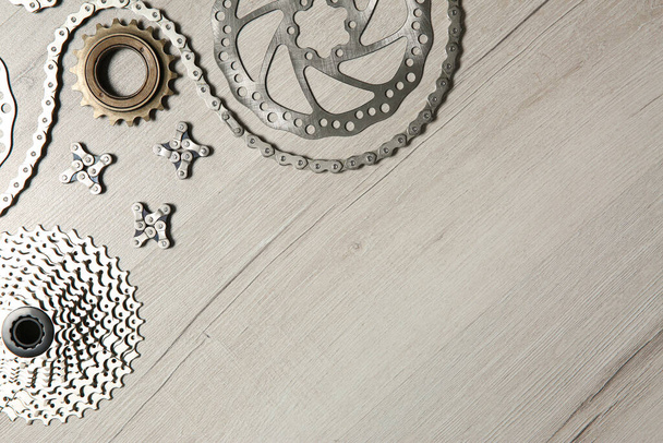 Set of different bicycle parts on wooden background, flat lay. Space for text - Foto, afbeelding
