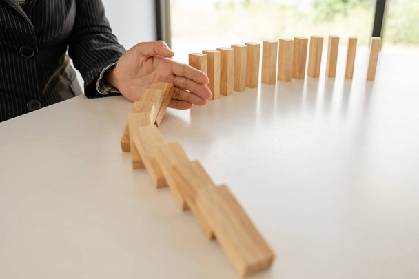 Woman hand stop wooden blocks for protect other wooden block, Concept Risk of management and strategy plan. - Photo, Image