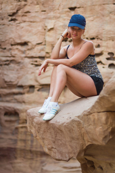 Egy lány ül egy sziklán. - Fotó, kép