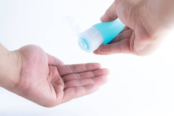 Hand cleaning gel. Pouring sanitising hand gel onto the hands of a hand. Cleaning germs on the hands using alcohol. - Photo, image