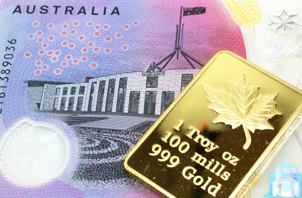 Una imagen macro de un billete australiano de cinco dólares con una barra de oro. Disparo de cerca
. - Foto, Imagen