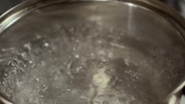 Boiling water in pan, slow motion, shallow depth of field - Video, Çekim
