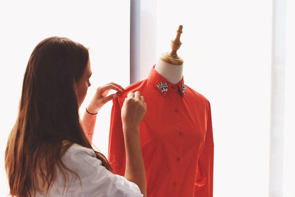 Muotisuunnittelija studio mittaus tekstiili materiaali leikkaus ompelu kangas nainen suunnittelija tyylikäs näyttelytila / suunnittelija työskentelee ammattilainen mittaamalla vaatteet räätälöintiä mallinuket työpajassa
 - Valokuva, kuva