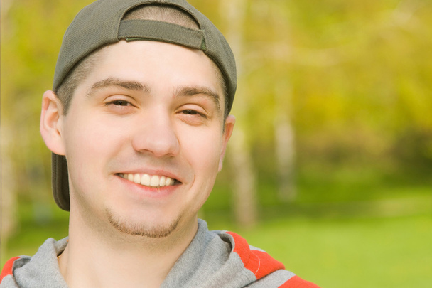 usmíval se neformální mladý muž v parku - Fotografie, Obrázek