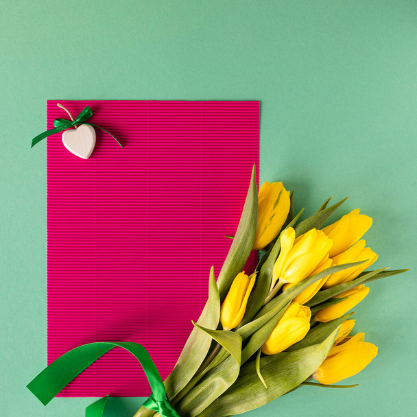 Belo arranjo de flores. Flores amarelas tulipas, moldura vazia para texto em um fundo verde. Casamento. Aniversário Dia dos Namorados. Dia das Mães. Deitado plano, vista superior
 - Foto, Imagem