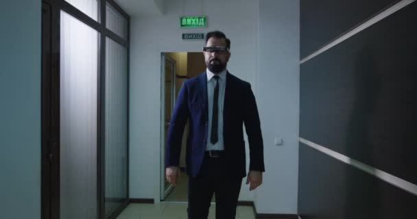 Liikemies, joka käyttää VR-laseja toimistokäytävällä
 - Materiaali, video