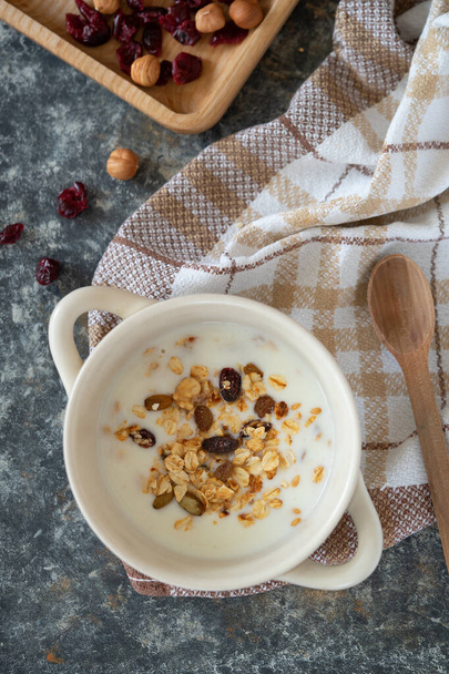Yoghurt bowl with granola in a white bowl, top view. Healthy vegan food breakfast concept. - Φωτογραφία, εικόνα