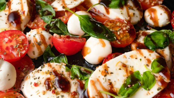 Моцарелла и помидоры черри, базилик и салат из бальзамического уксуса. Итальянская кухня. Макро
 - Фото, изображение