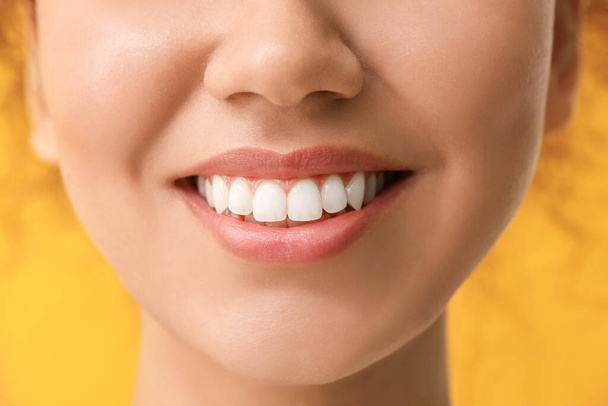 Щаслива жінка зі здоровими зубами на кольоровому фоні, крупним планом
 - Фото, зображення