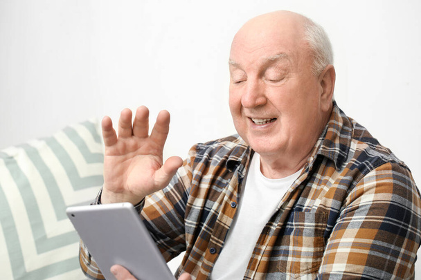 自宅でタブレットコンピュータを持つ高齢者の肖像 - 写真・画像