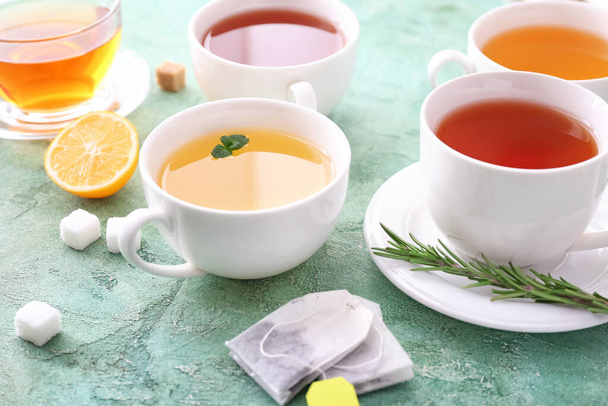 Tazas con diferentes tipos de té caliente sobre fondo de color - Foto, imagen