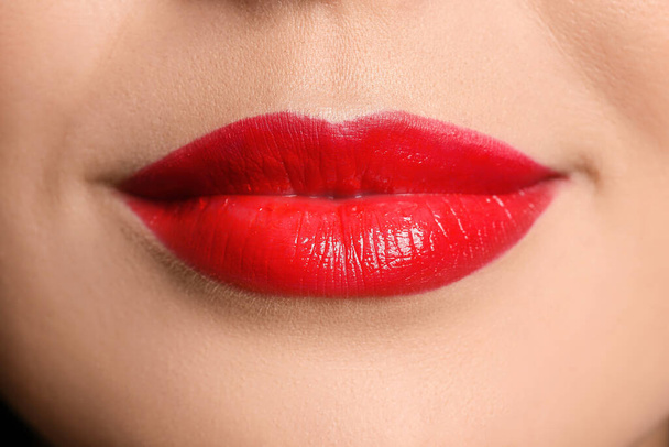 Jonge vrouw met rode lippenstift, close up - Foto, afbeelding