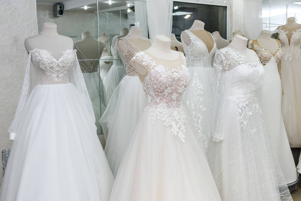Vestidos de novia de moda en percha y maniquíes en el salón
 - Foto, Imagen