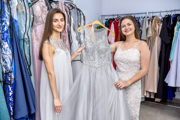 Друзья в магазине одежды ищут платья
 - Фото, изображение