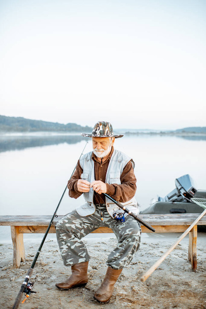 Hombre mayor pescando en el lago
 - Foto, imagen