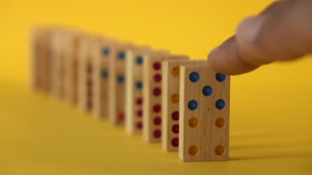 Langzame beweging van dominostenen die op gele achtergrond vallen - Video