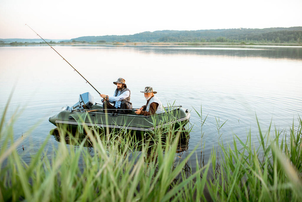 Grandfather with son fishing on the boat - 写真・画像