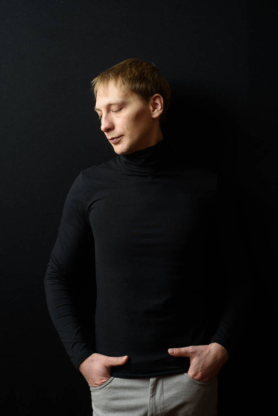 Portrait of determined goodlooking man wearing black clothes, black background. - Foto, Bild
