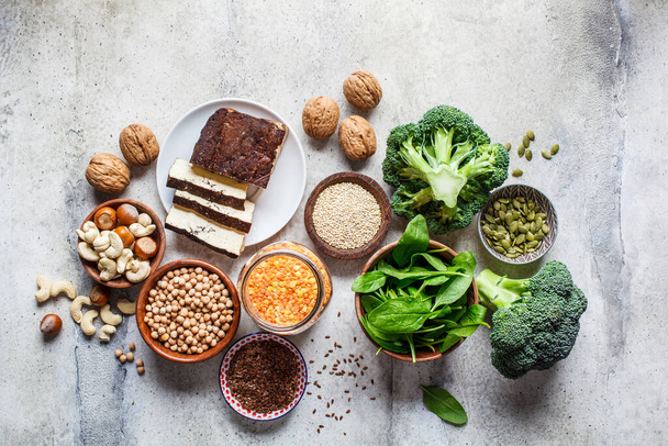 Vegan sources of protein background, top view. Tofu, chickpeas, lentils, nuts, spinach and broccoli are vegetable proteins. - Foto, imagen