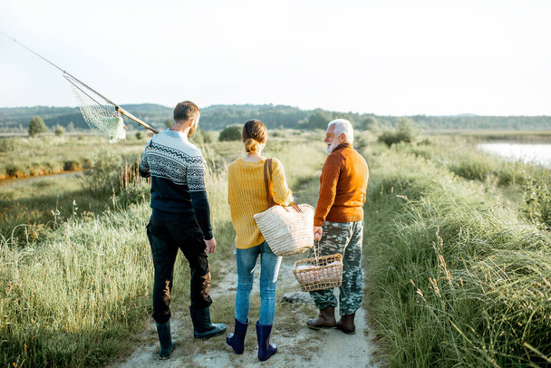 Young man and woman with senior grandfather walking outdoors - Fotoğraf, Görsel