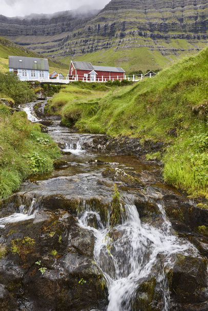 Traditional Faroe village of  Kunoy with picturesque stream and mountain - Photo, Image